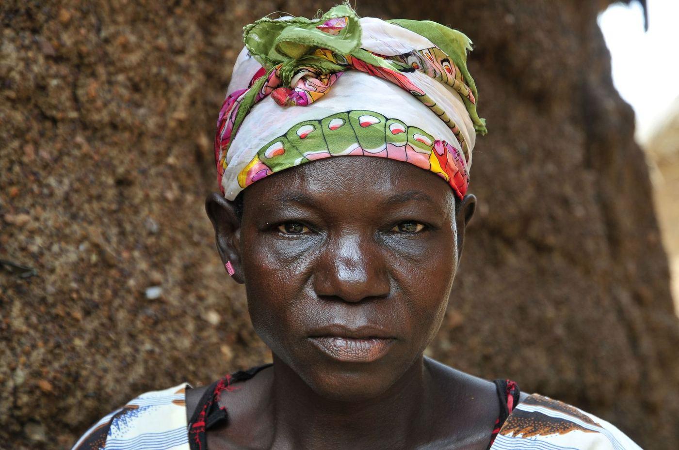A farmer standing at her home in Ghana